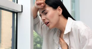 Young,woman,suffering,from,breathing,problem,near,window,indoors